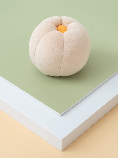 Plush peach toy on a green and beige background