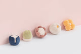 Set of colorful fabric toys on a light pink background