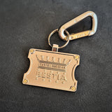 Gold keychain with carabiner on a dark background