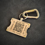 Brass animal ID tag with QR code on a black background