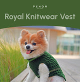 Dog wearing a green knitwear vest with 'PEHOM' branding on a blurred outdoor background.